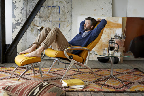 man relaxes on his recliner in his trendy home